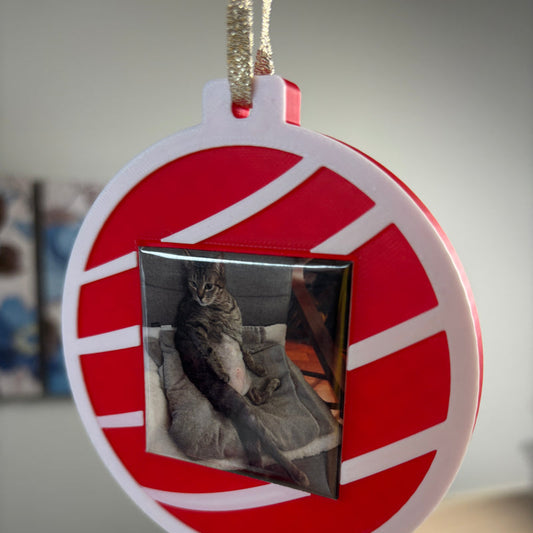 Red Keepsake Ornament with a cat photo magnet, hanging from a gold ribbon